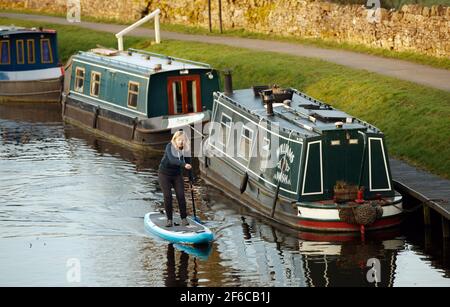 Joanna Moseley, the first woman to paddleboard along the 162-mile Canal and River Trust Coast-to-Coast Trail, pledges her support for Canal and River Trust's Plastics Challenge, as she paddleboards at the Greenberfield Locks near Barnoldswick, Lancashire. Picture date: Wednesday March 31, 2021. Stock Photo