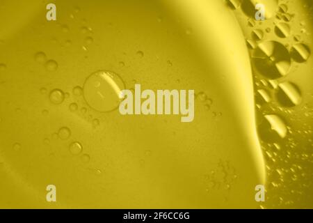 Macro fluid with bubbles, abstract yellow background. Selective focus. Stock Photo