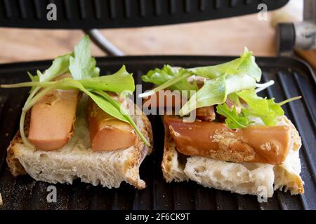 preparing toast made with bread wurstel and mixed green salad Stock Photo