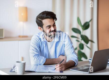 Successful Eastern Entrepreneur Working With Documents And Laptop At Home Office Stock Photo
