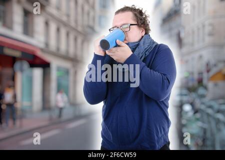 Young attractive guy is drinking a hot drink. Stock Photo