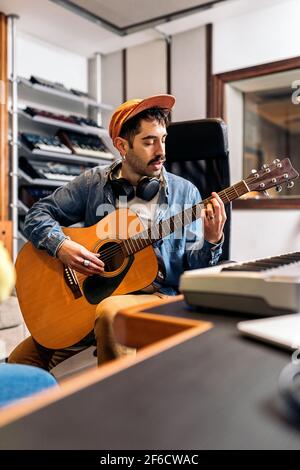 Stock photo of concentrated artist in music studio playing the guitar. Stock Photo