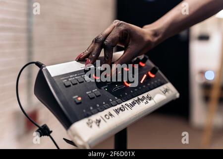Stock photo of unrecognized black woman in professional music studio using equipment. Stock Photo