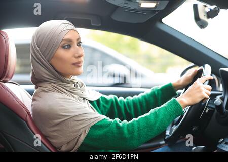 Cheerful muslim woman driving her new car Stock Photo