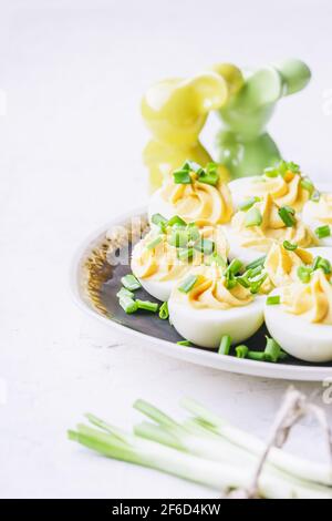 Deviled eggs in rustic ceramic plate, Easter brunch snack, close up Stock Photo