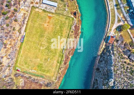 Obrovac. Soccer field by Zrmanja river aerial view. Karst landscape of Obrovac, town in Dalmatia region of Croatia Stock Photo