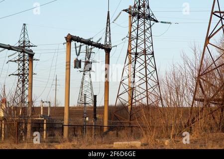 A high-voltage power line next to an electrical substation. Stock Photo