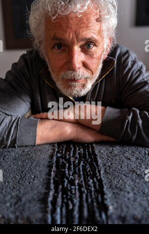 mature potter showing a black clay composition in his studio Stock Photo