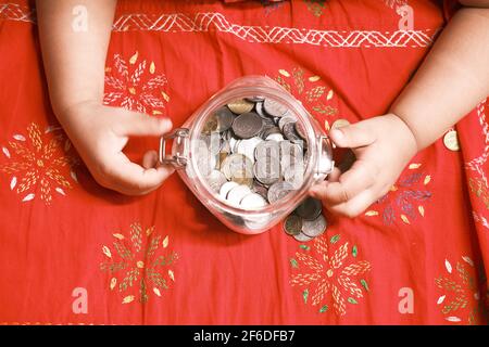 child girl pile coin for saving on bed , top view  Stock Photo