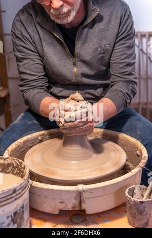 pottery craftsman working on a potters wheel to make a new bowl Stock Photo