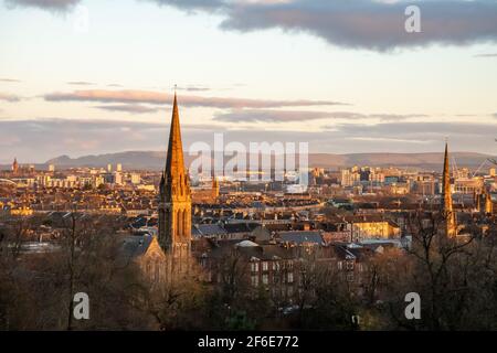 Looking north across the city centre of Glasgow, Scotland towards the Campsie Hills from Queen's Park in the Southside at sunrise on a winter morning. Stock Photo