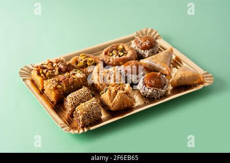 Assortment of Ramadan dessert baklava on green background Stock Photo