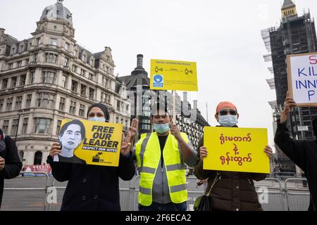 London, UK. 31st Mar, 2021. Protesters with placards and doing the three-finger salute of resistance in Parliament Square. Protesters gathered in Parliament Square - wearing face masks and observing social-distancing - before marching to the Chinese Embassy in solidarity with the people of Myanmar against the military coup and state killings of civilians. Speeches were given outside the embassy. Since the beginning of the military coup on the 1st of February over 520 people have been killed in Myanmar by security forces. Last Saturday was the most violent day when more than 100 people were kil Stock Photo