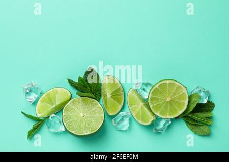 Lime slices, ice cubes and mint leaves on mint background Stock Photo