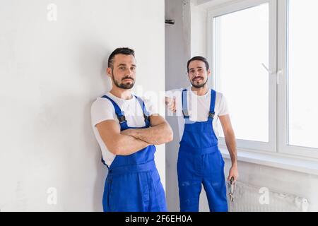 Two experienced builder in uniform posing for a photo Stock Photo