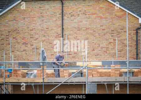 London, UK - 5 February, 2021 - A bricklayer working at a home building construction site Stock Photo
