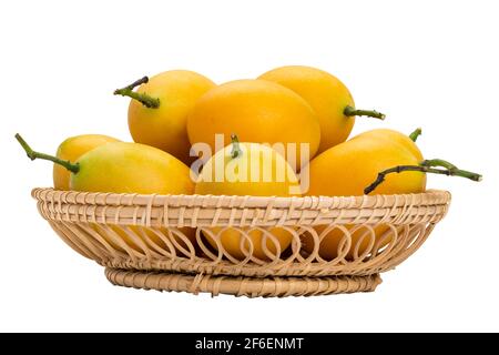 Closeup of ripe Marian Plum in bamboo basket on white background with clipping path. Delicious sweet yellow marian plum in Thailand. Stock Photo