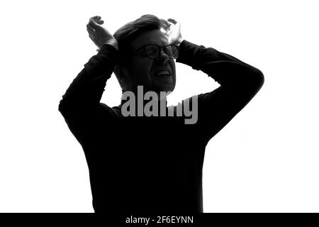 Silhouette of young man having headache pressing with hands on temples isolated over white background. Stock Photo