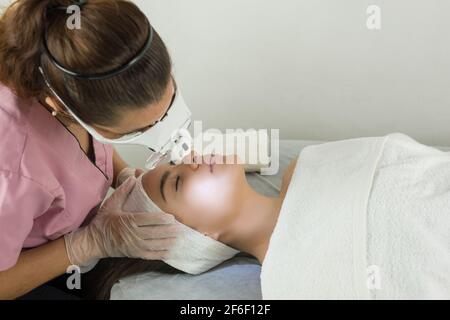 Expert cosmetologist making a deep cleansing facial Stock Photo