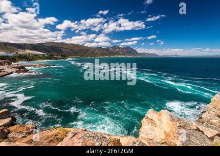 Scenic view of Hermanus and Walker Bay from cliff path near Cape Town, South Africa against blue sky with clouds Stock Photo