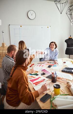 Two female designers sharing the pencil at the table Stock Photo