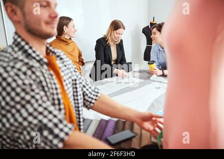Positive friendly designers and tailors working together Stock Photo