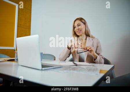 Positive delighted female person having online meeting Stock Photo