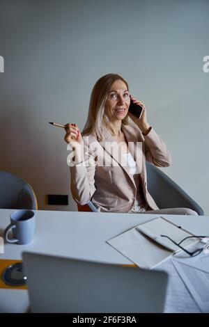 Pretty blonde female person talking per telephone Stock Photo