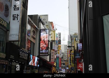 Commercial alleyway in downtown Myeongdong, Seoul, with distant view of Namsan Tower Stock Photo