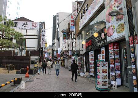 People walking past restaurants in Myeongdong, Seoul Stock Photo