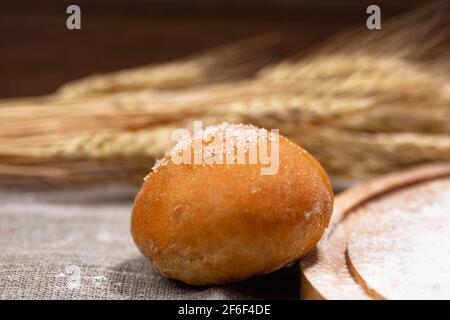 homemade bun against the background of wheat ears Stock Photo