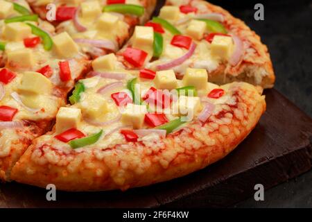 Pizza Paneer Makhani , home made delicious  pizza  made using red and green bell pepper ,onion ,paneer and mozzarella cheese,thin pastry crust placed Stock Photo