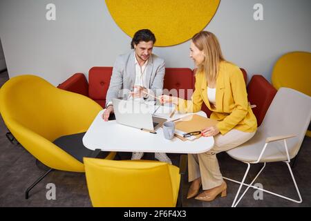 Two friendly people having pleasant conversation in office Stock Photo