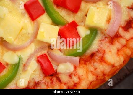 Pizza Paneer Makhani , home made delicious  pizza  made using red and green bell pepper ,onion ,paneer and mozzarella cheese,thin pastry crust placed Stock Photo