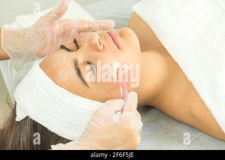 Expert cosmetologist making a deep cleansing facial Stock Photo