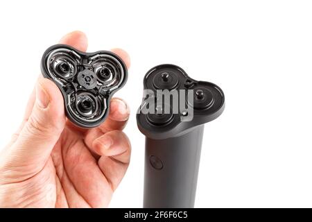 caucasican hand holding three razor head of black electric shaver - isolated. Stock Photo