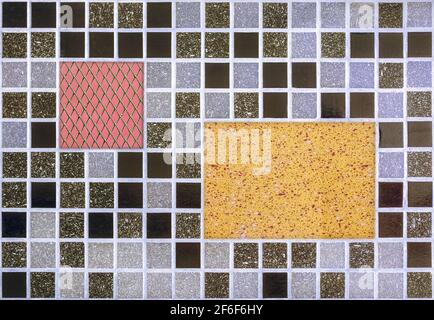 Part of the wall, lined with gray mosaic tiles with rectangular inserts in the background, for use as a seamless background. Stock Photo