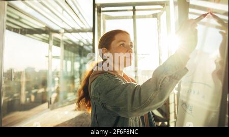 Student writing on whiteboard. Young woman studying in college. Stock Photo