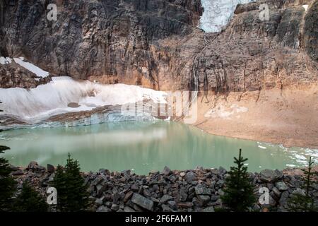 Emerald glacier-fed pool below the Angel Glacier, or Ghost Glacier, from the Mount Edith Cavell Meadows hike in the Canadian rockies in Jasper. Stock Photo