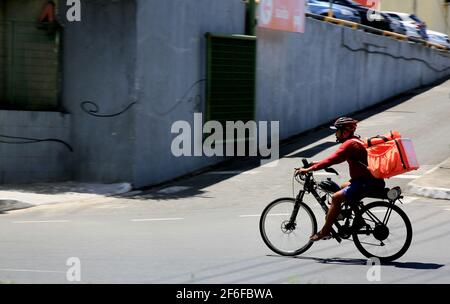 salvador, bahia, brazil - december 30, 2020: food delivery man by application is seen traveling with motorized bicycle in the city of Salvador. Stock Photo