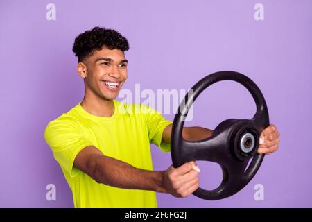 Photo portrait of young curly guy keeping steering wheel smiling preparing for driving exam isolated on pastel violet color background Stock Photo
