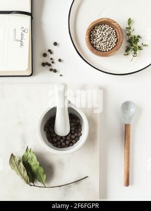 Kitchen background with various kitchen utensils, spices and recipe pad on light background. Top view Stock Photo