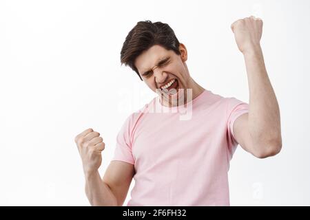 Oh yeah baby. Smiling satisfied man celebrated success, making fist pump like champion, winning and celebrating, triumphing, say yes with pleased face Stock Photo