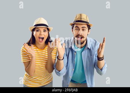 Close up portrait of a surprised married couple who found cheap plane tickets for vacation. Stock Photo