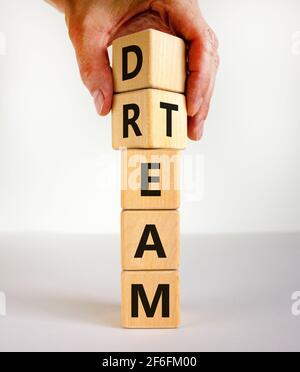 Dream team symbol. Businessman turns cubes and changes the word 'dream' to 'team'. Beautiful white table, white background. Business and dream team co Stock Photo