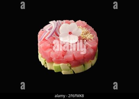 Tuna tartare, avocado, red onion, garlic, basil, capers, lotus root, tobiko caviar, lemon, chives. Isolated on black background Stock Photo