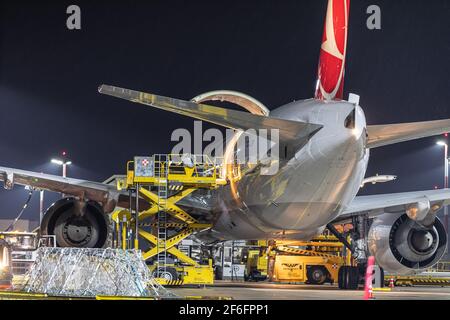 Hoersching, Austria - March 21 2021: A Turkish Cargo Boeing 777F freighter plane on Linz Airport at night Stock Photo