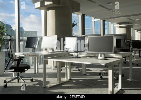 Modern office desks with computers in corporate interior Stock Photo