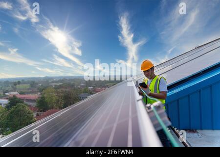 engineers use a tablet checking solar power station on roof the operation of the system, Alternative energy to conserve the world's energy, clean ener Stock Photo