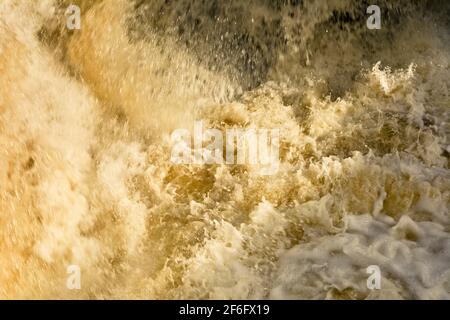 Water turbulent flowing out of the weir Stock Photo